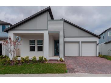 Beautiful modern home featuring a brick driveway, a two-car garage, and gray-and-white paint at 16271 Silver Grove Blvd, Winter Garden, FL 34787