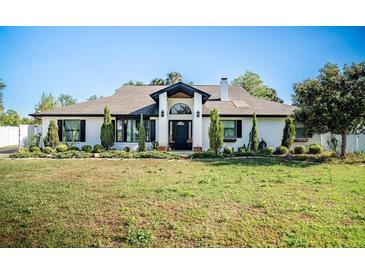 Charming single-story home featuring a manicured front yard, classic design, and black trim windows at 1651 Big Oak Ln, Kissimmee, FL 34746