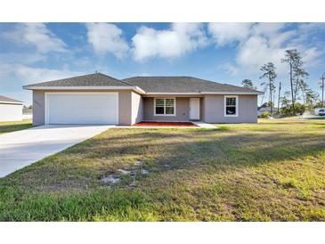 A charming one-story home with a well-maintained lawn and a two-car garage, ideal for suburban living at 16771 Sw 21St Terrace Rd, Ocala, FL 34473