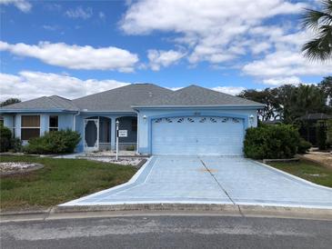Charming single-story home featuring a well-manicured lawn and a two-car garage at 1805 San Luis Ln, The Villages, FL 32159