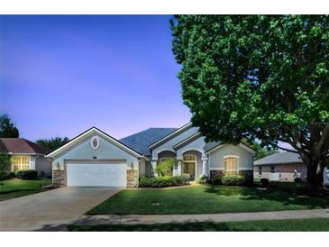 Charming single-story home with attached garage and a beautifully landscaped front yard at 212 Hazeltine Dr, Debary, FL 32713