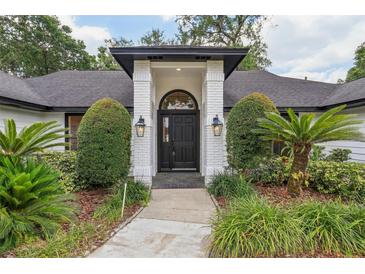 Inviting front entrance featuring a black door, white brick pillars, and professionally landscaped yard at 216 Shady Oaks Cir, Lake Mary, FL 32746