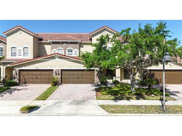 Beautiful townhome featuring a red tile roof, brown garage doors, and a paver driveway at 2167 Velvet Leaf Dr, Ocoee, FL 34761