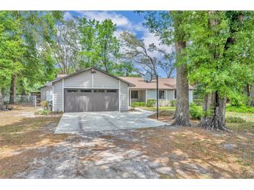 Charming single-story home with a two-car garage, a basketball hoop and a spacious driveway, nestled among mature trees at 217 E Hillcrest St, Altamonte Springs, FL 32701