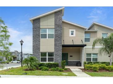 Charming two-story home with a mix of stone and stucco exterior, front yard, and a covered porch at 2400 Reading Trl, Kissimmee, FL 34746