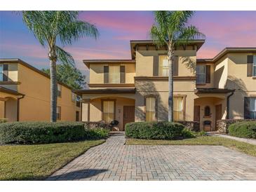 Charming townhome featuring a meticulously landscaped yard and a brick-paved walkway at 309 Verona Ave, Davenport, FL 33897