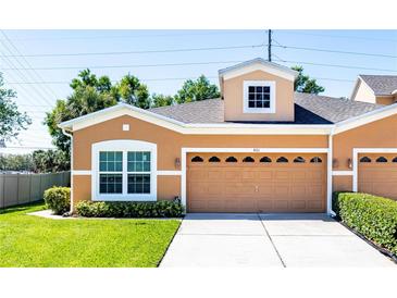 Charming townhome with well-manicured lawn, two-car garage, and neutral color scheme exudes curb appeal at 401 Harbor Winds Ct, Winter Springs, FL 32708