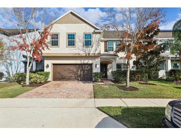 Charming two-story home boasts a well-maintained lawn, mature landscaping and a brick paved driveway leading to a two-car garage at 611 Marsh Reed Dr, Winter Garden, FL 34787