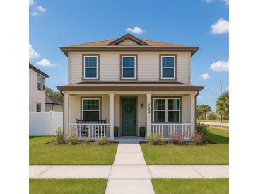 Charming two-story home featuring a welcoming front porch, verdant lawn, and well-maintained landscaping at 900 S Maple Ave, Sanford, FL 32771
