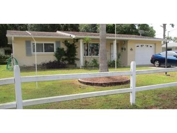 Charming single-story home with a well-maintained front yard, fenced in with an attached garage at 116 E Palm Way, Edgewater, FL 32132