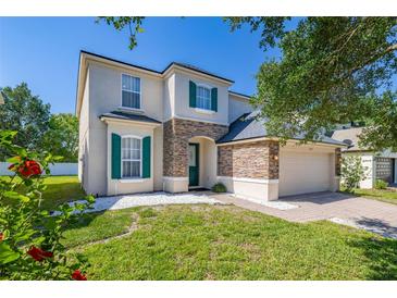 Charming two-story home features green shutters, a stone accent wall, and well-maintained landscaping at 13247 Hatherton Cir, Orlando, FL 32832