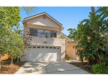 Charming two-story home with a two-car garage and tropical landscaping at 1450 Harbour Dr, Longwood, FL 32750