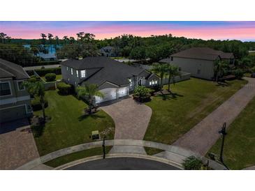 Stunning two-story home with a well-manicured lawn, brick driveway and lush landscaping providing great curb appeal at 17106 Guilford Ct, Orlando, FL 32820