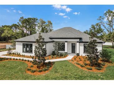 Stunning single story home featuring manicured lawn, mulched flower beds, and a dark-trimmed facade at 18026 Reynolds Pkwy, Orlando, FL 32833