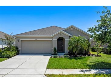 Charming single-story home features a well-manicured lawn, neutral exterior, and a two-car garage at 1918 Marabou Dr, Davenport, FL 33896