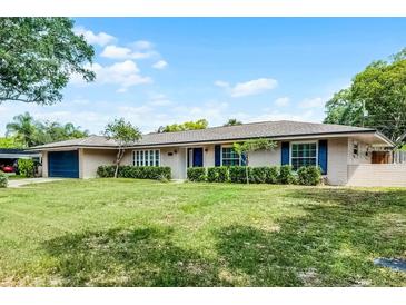 Charming single-story home featuring a well-maintained lawn, complemented by manicured hedges and blue shutters at 2311 Huron Trl, Maitland, FL 32751