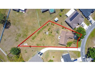 Aerial view of a property with a spacious lot, mature trees and long driveway at 241 Churchill Ct, Kissimmee, FL 34758