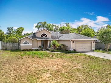 Charming single-story home featuring a two-car garage, landscaped yard, and neutral exterior paint at 2850 Tremont Dr, Eustis, FL 32726
