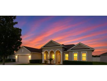 Charming single-story home with a well-manicured lawn set against a beautiful sunset sky at 36300 Grand Island Oaks Cir, Grand Island, FL 32735