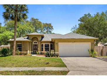 Charming single-story home with mature landscaping, a large driveway, and a two-car garage at 4371 Vestawood Ct, Sanford, FL 32773