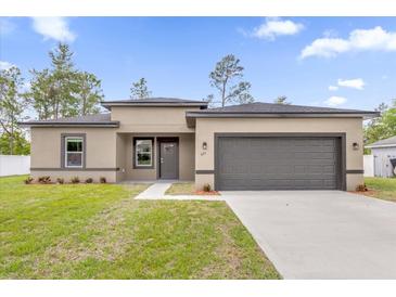 Charming single-story home with a neutral color scheme, well-manicured lawn, and a two-car garage at 601 Marion Oaks Blvd, Ocala, FL 34473