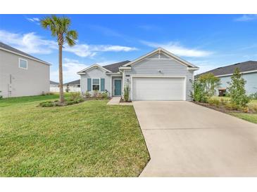 Charming one-story home featuring a well-maintained lawn, light-blue siding, and an attached two-car garage at 9132 Sw 57Th Ter, Ocala, FL 34476