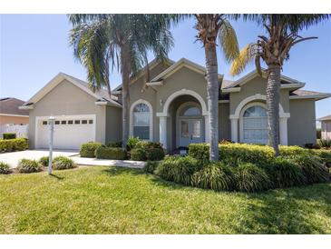 Charming single-story home boasts mature landscaping, an arched entryway, and a two-car garage at 212 Terranova Blvd, Winter Haven, FL 33884