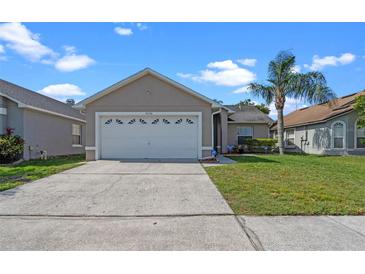 Charming single-story home featuring a concrete driveway, a two-car garage and a well-manicured lawn at 3220 Harpers Ferry Ct, Orlando, FL 32837