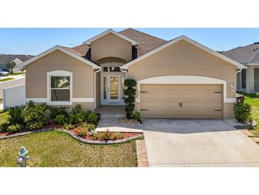 Charming single-story home featuring a well-manicured lawn and a two-car garage at 4026 Ruby Run, Haines City, FL 33844