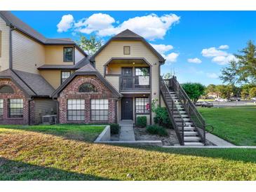 Charming condo featuring a brick facade, balcony, and staircase leading to the entrance at 420 Forestway Cir # 108, Altamonte Springs, FL 32701