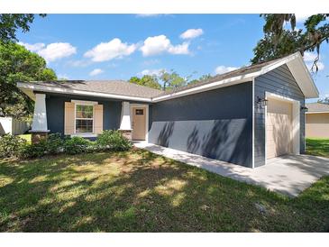 Charming single-story home featuring blue siding, a well-manicured lawn, and an attached one car garage at 510 Fahnstock St, Eustis, FL 32726