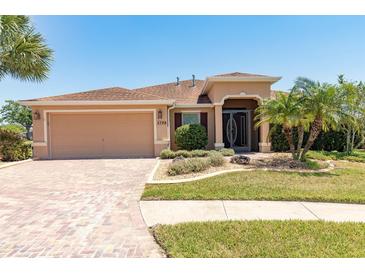 Charming single-story home with a well-manicured lawn, two-car garage, and inviting front entrance at 5799 Linen Bluff Pl, Leesburg, FL 34748