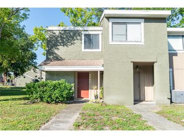 Charming two-story townhome featuring a textured exterior and cozy front porch at 5961 Windhover Dr # F05, Orlando, FL 32819