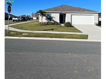 Well-maintained single-story home with attached garage and manicured front lawn on a sunny day at 604 Sarner Pass Way, Winter Haven, FL 33881