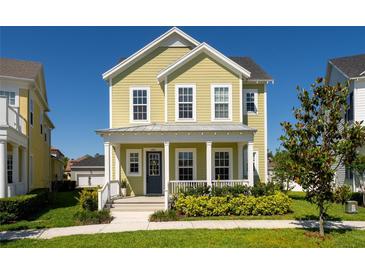 Charming two-story home with a welcoming front porch, lush landscaping, and a well-maintained lawn at 7409 Inlet Pt, Celebration, FL 34747