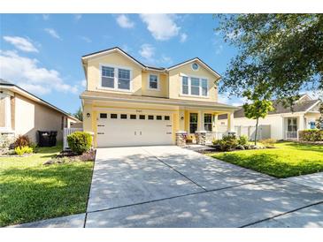 Inviting two-story yellow home with a well-manicured lawn and a spacious two-car garage at 7545 Azalea Cove Cir, Orlando, FL 32807