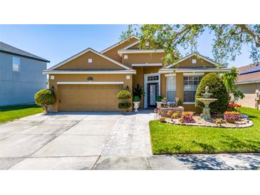 Charming tan home with landscaped front yard and decorative fountain on a sunny day at 8856 Hastings Beach Blvd, Orlando, FL 32829