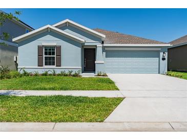 Charming single-story home with a well-manicured lawn and two-car garage at 917 Jackson Ave, Davenport, FL 33837