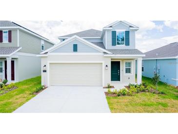 Charming two-story home with a large garage and neatly manicured lawn in a Gathering-friendly neighborhood at 921 Jackson Ave, Davenport, FL 33837