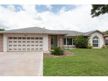 Charming single-story home featuring a well-manicured lawn and attached two-car garage at 935 Amy Ridge Ct, Kissimmee, FL 34747