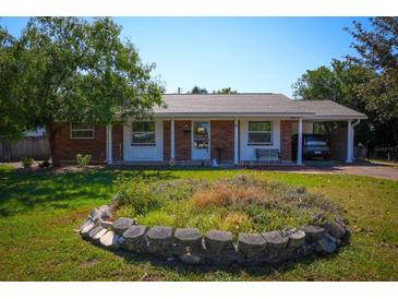 Charming single-story brick home featuring a well-maintained front yard, carport, and classic architectural details at 1 Cosmos Dr, Orlando, FL 32807