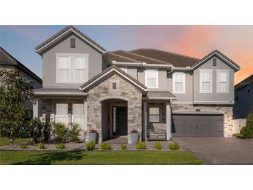 Charming home with stone accents, covered entry, and a well-manicured lawn at 10626 Bonne Chance Dr, Orlando, FL 32832