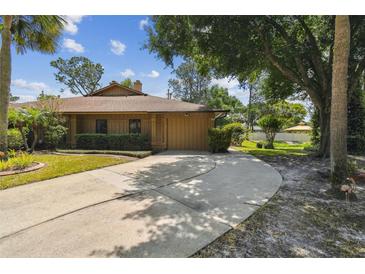 Charming single-story home with a well-manicured lawn, a two-car garage, and a circular driveway at 194 Heron Bay Cir, Lake Mary, FL 32746
