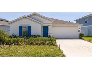 Charming single-story home with a well-manicured lawn and a bright blue front door at 6935 Dilly Lake Ave, Groveland, FL 34736