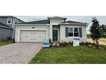 Charming single-story home with a two-car garage, featuring a well-maintained lawn and inviting front entrance at 738 Pointe Emerson Blvd, Apopka, FL 32703