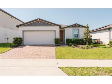 Charming single-story home with a well-manicured lawn and brick driveway at 849 Teton St, Haines City, FL 33844