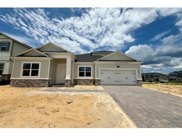 Charming single-story home with a two-car garage and beautiful stone accents at 873 Pointe Emerson Blvd, Apopka, FL 32703