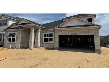 An unfinished exterior of a single-Gathering home shows the block construction and attached two-car garage at 873 Pointe Emerson Blvd, Apopka, FL 32703