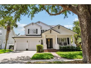 Charming two-story home featuring a well-manicured lawn, brick walkway, white columns, and a two-car garage at 9684 Sweetleaf St, Orlando, FL 32827