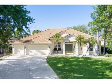 Charming single-story home boasts a well-manicured lawn, mature trees and an attached three-car garage at 11025 Ledgement Ln, Windermere, FL 34786